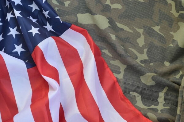 USA flag laying over camo uniform